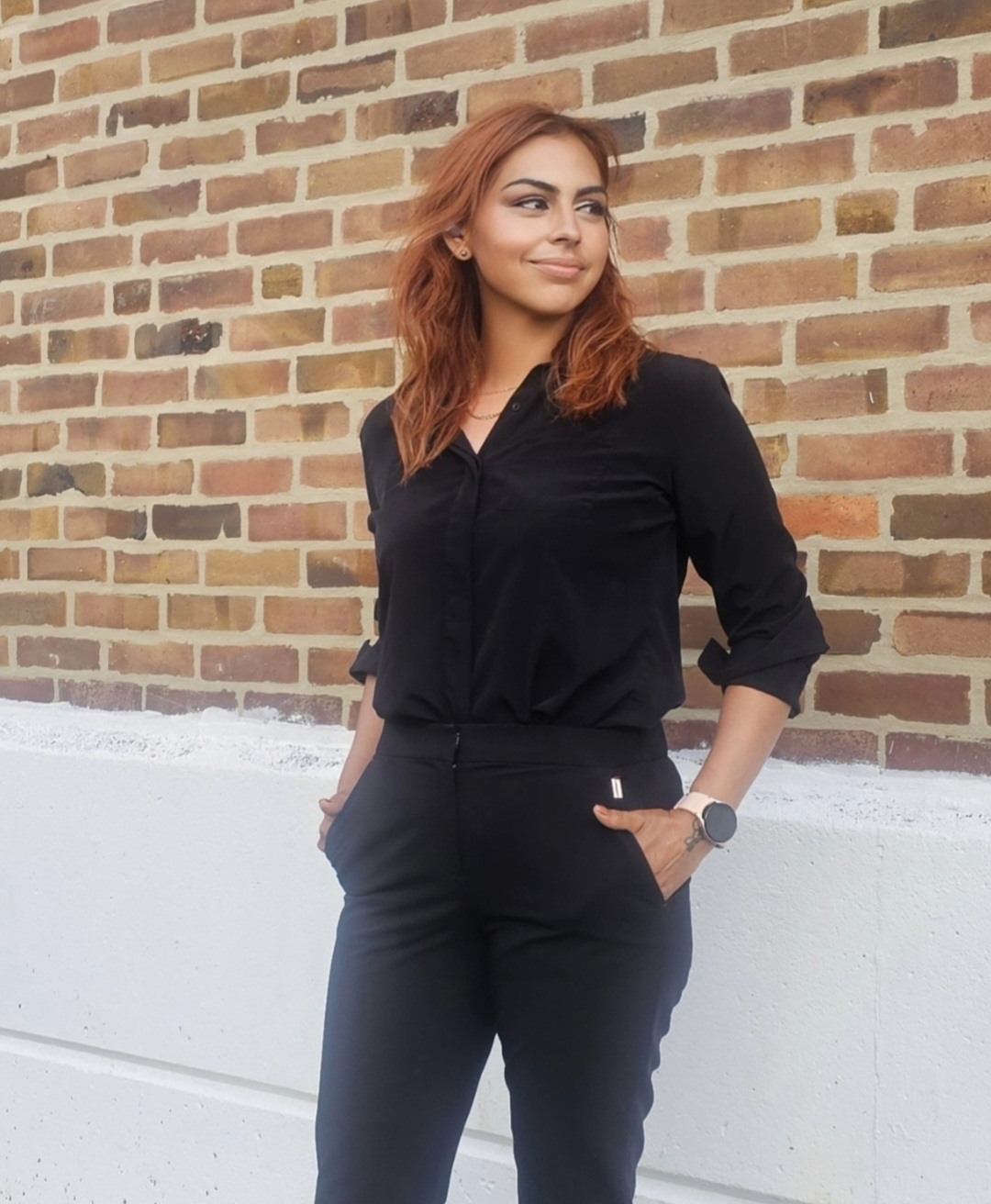 Gigi Ascend founder standing confidently in front of brick wall